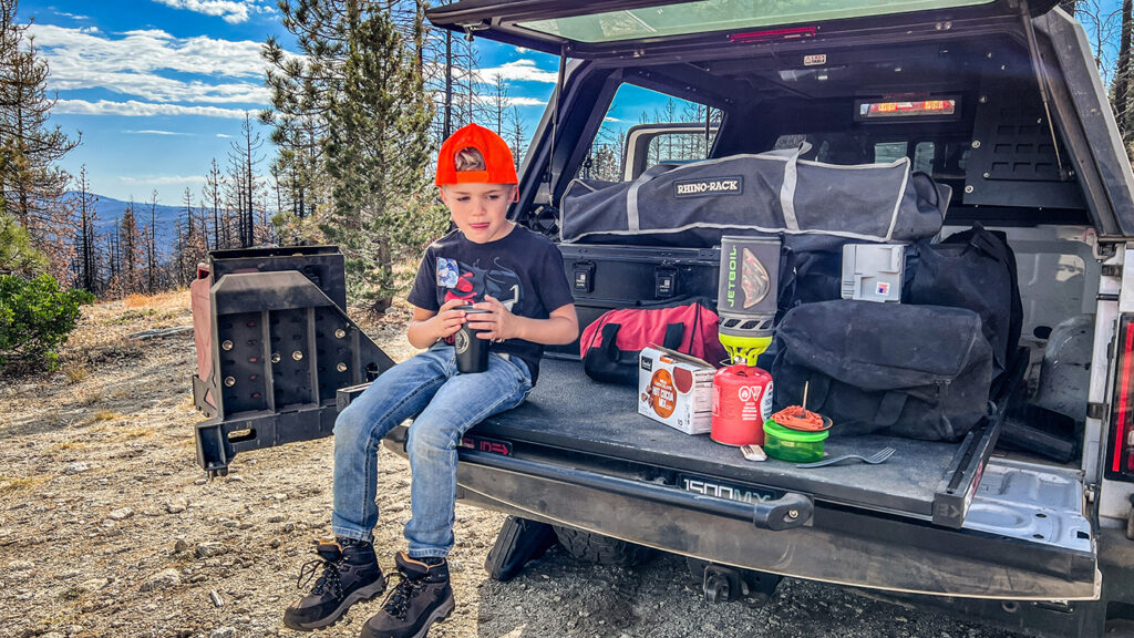 Kid enjoying dring in pickup truck trailgate with BEDSLIDE
